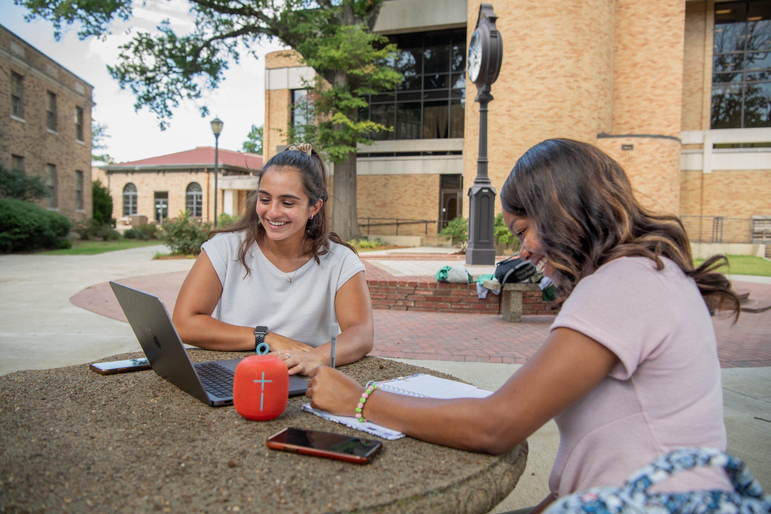 2 students looking at laptop for scholarship information.